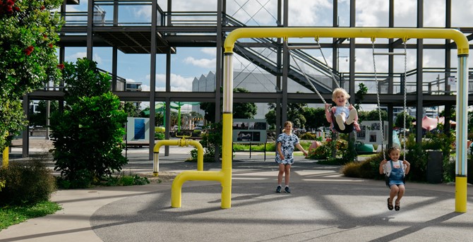 Children playing on the new swing set at Silo Park